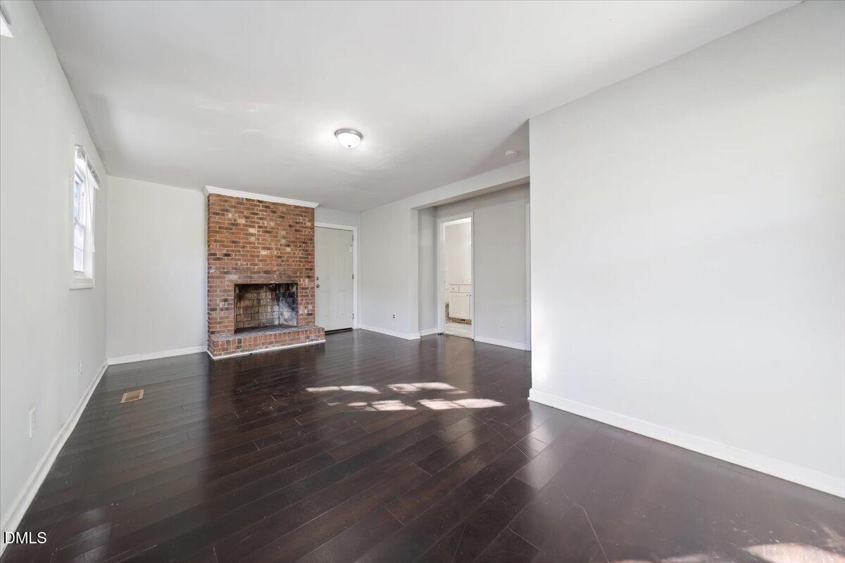 1213 Tarboro Street Southwest Wilson, NC 27893 - Photo 9 of 27 a view of an empty room with a window and wooden floor