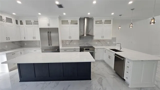 a large kitchen with stainless steel appliances kitchen island a stove a sink a refrigerator and a oven