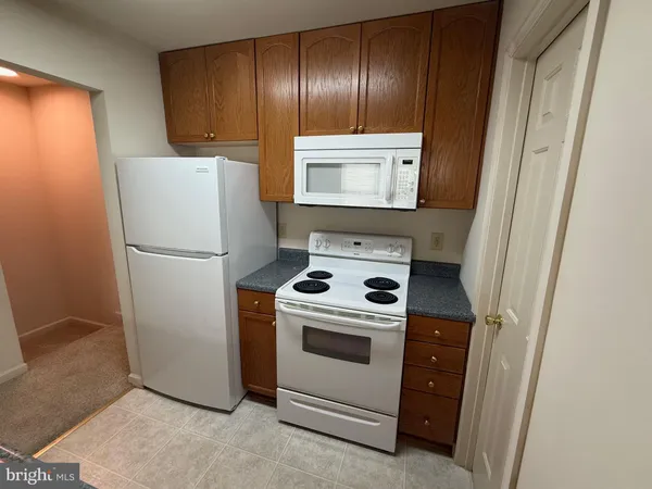 a kitchen with a stove refrigerator and microwave