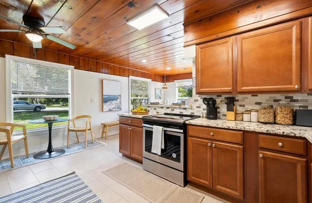 a kitchen with stainless steel appliances granite countertop a stove a sink and a microwave