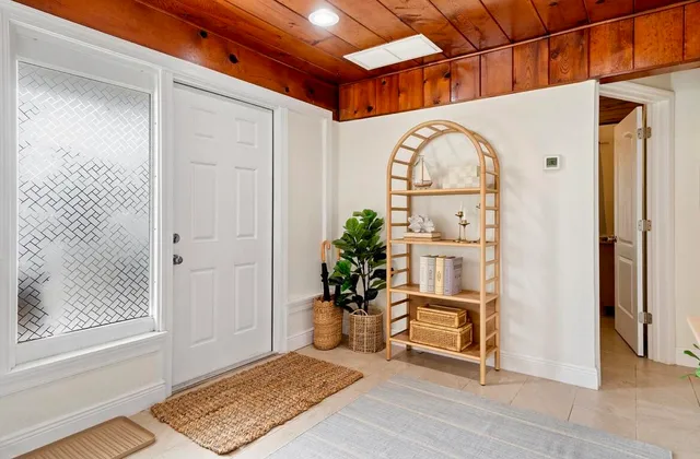 a view of a hallway with wooden floor and a dining room