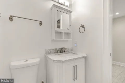 a bathroom with a sink a toilet and a mirror