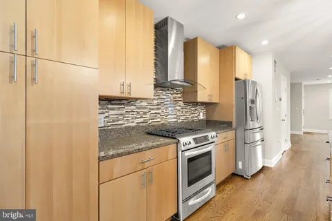 a kitchen with stainless steel appliances granite countertop a stove and a refrigerator