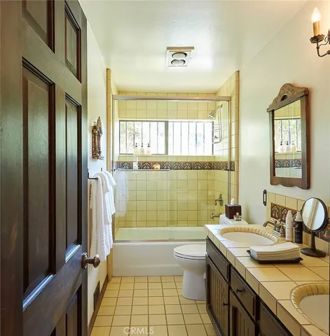 a bathroom with a granite countertop sink a toilet and shower