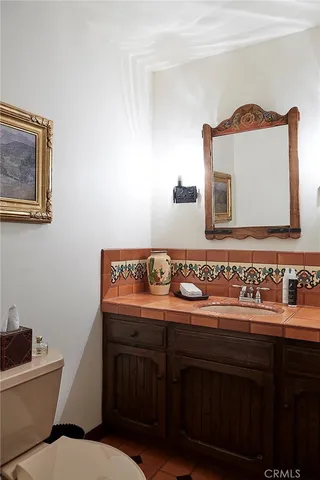 a bathroom with a toilet a sink and mirror