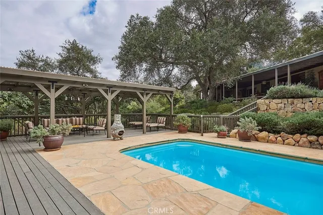swimming pool view with a seating space and garden view
