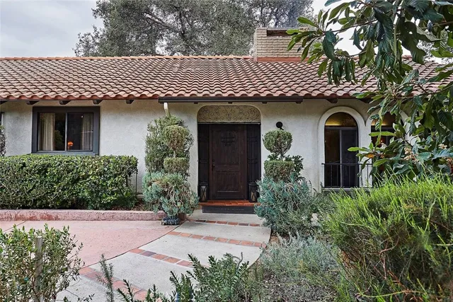 a front view of a house with a yard and trees