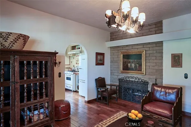 a living room with furniture a chandelier and a fireplace