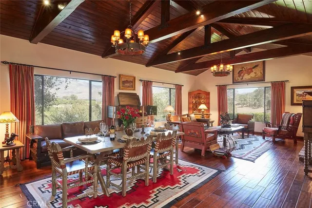 a living room with furniture large window and wooden floor