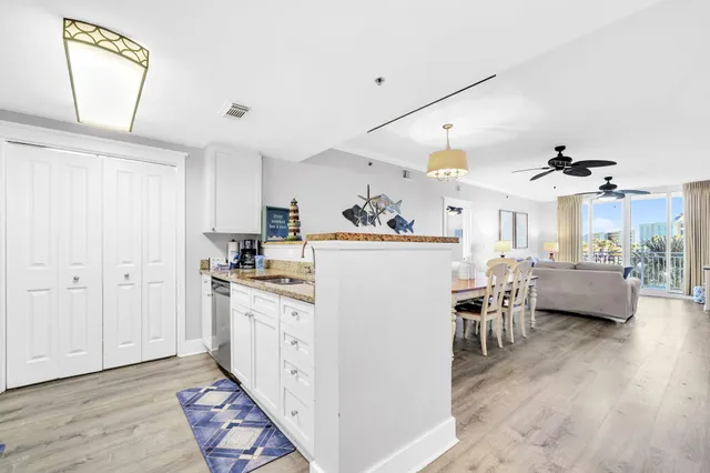 a kitchen that has a lot of white cabinets and wooden floor
