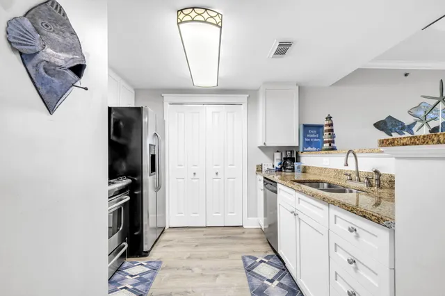 a kitchen with a sink stainless steel appliances and cabinets