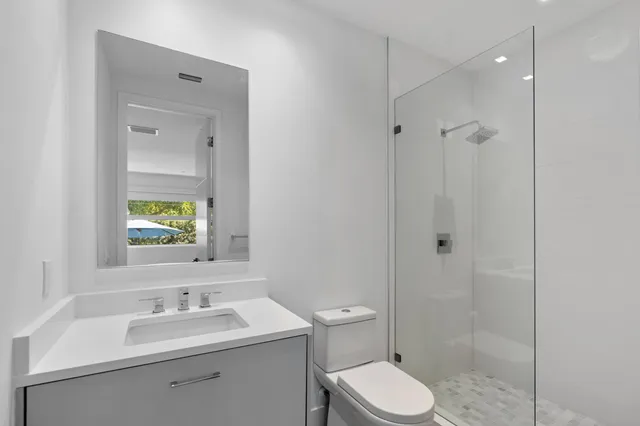 a bathroom with a toilet sink shower and mirror