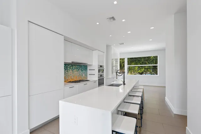 a large white kitchen with a large window