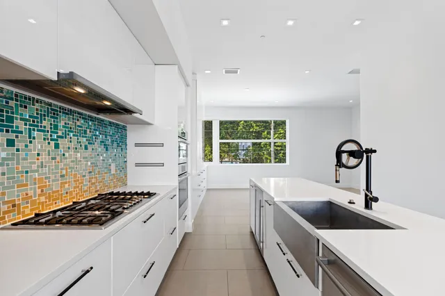 a kitchen with a sink and a stove top oven