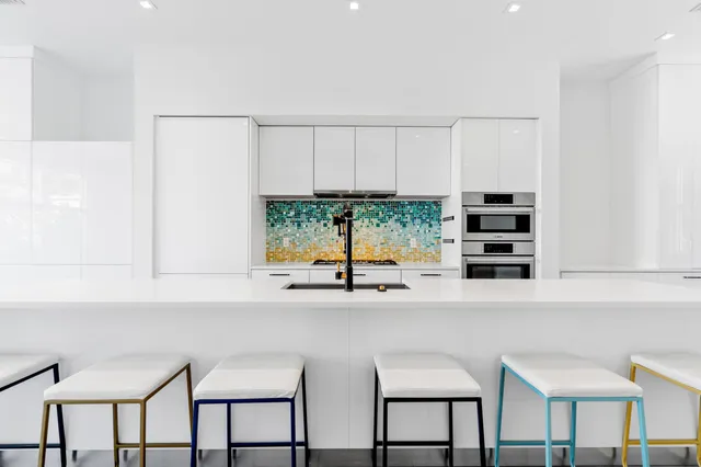 a kitchen with stainless steel appliances a white table chairs and a window