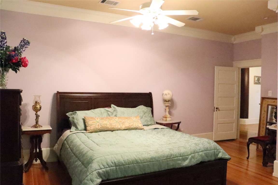 701 Sloan Street Taylor, TX 76574 - Photo 17 of 32 a bedroom with a bed and a chandelier