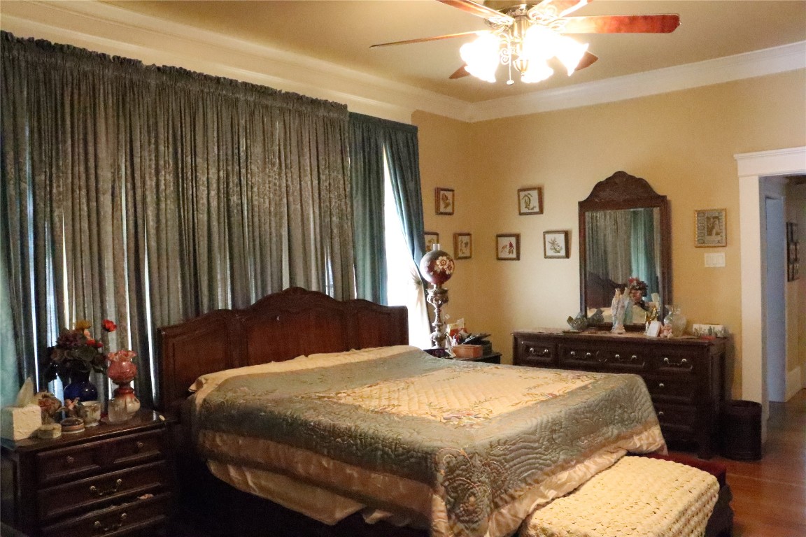 701 Sloan Street Taylor, TX 76574 - Photo 22 of 32 a bedroom with a bed and dresser with mirror