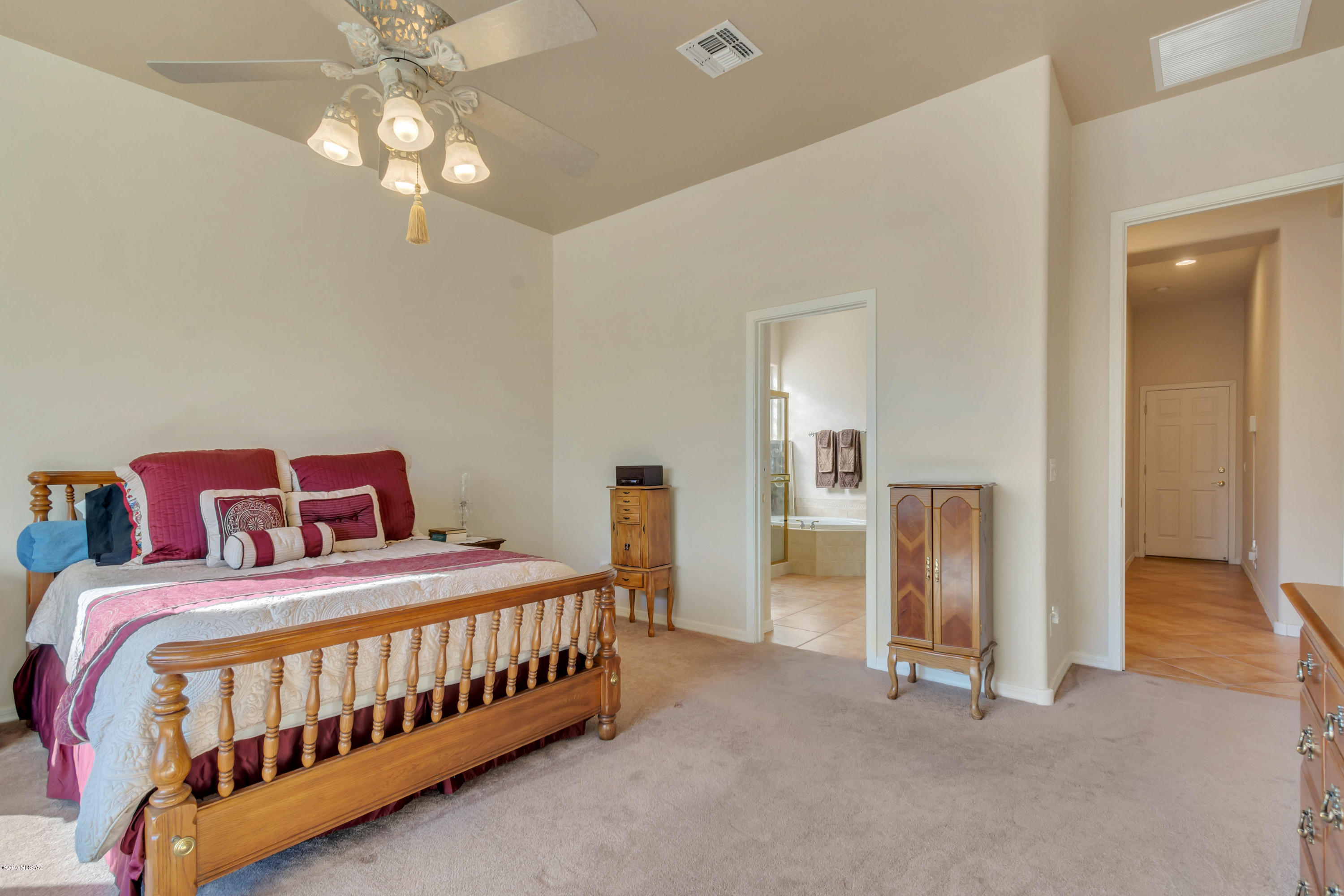 12682 North Spirit Mountain Road Oro Valley, AZ 85755 - Photo 37 of 40 a bedroom with a bed and a chandelier