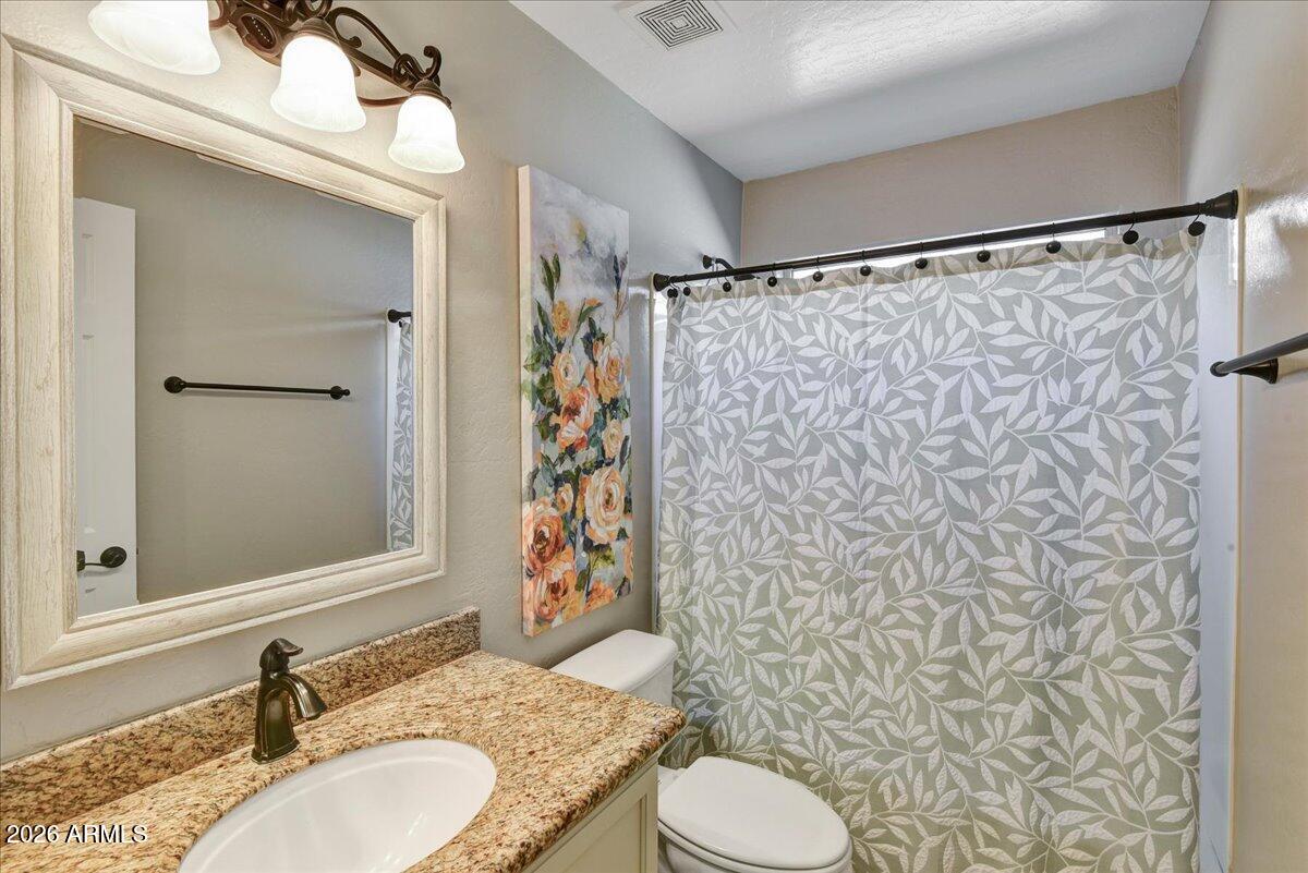 10830 West Almeria Road Avondale, AZ 85392 - Photo 12 of 27 a bathroom with a granite countertop sink toilet and shower