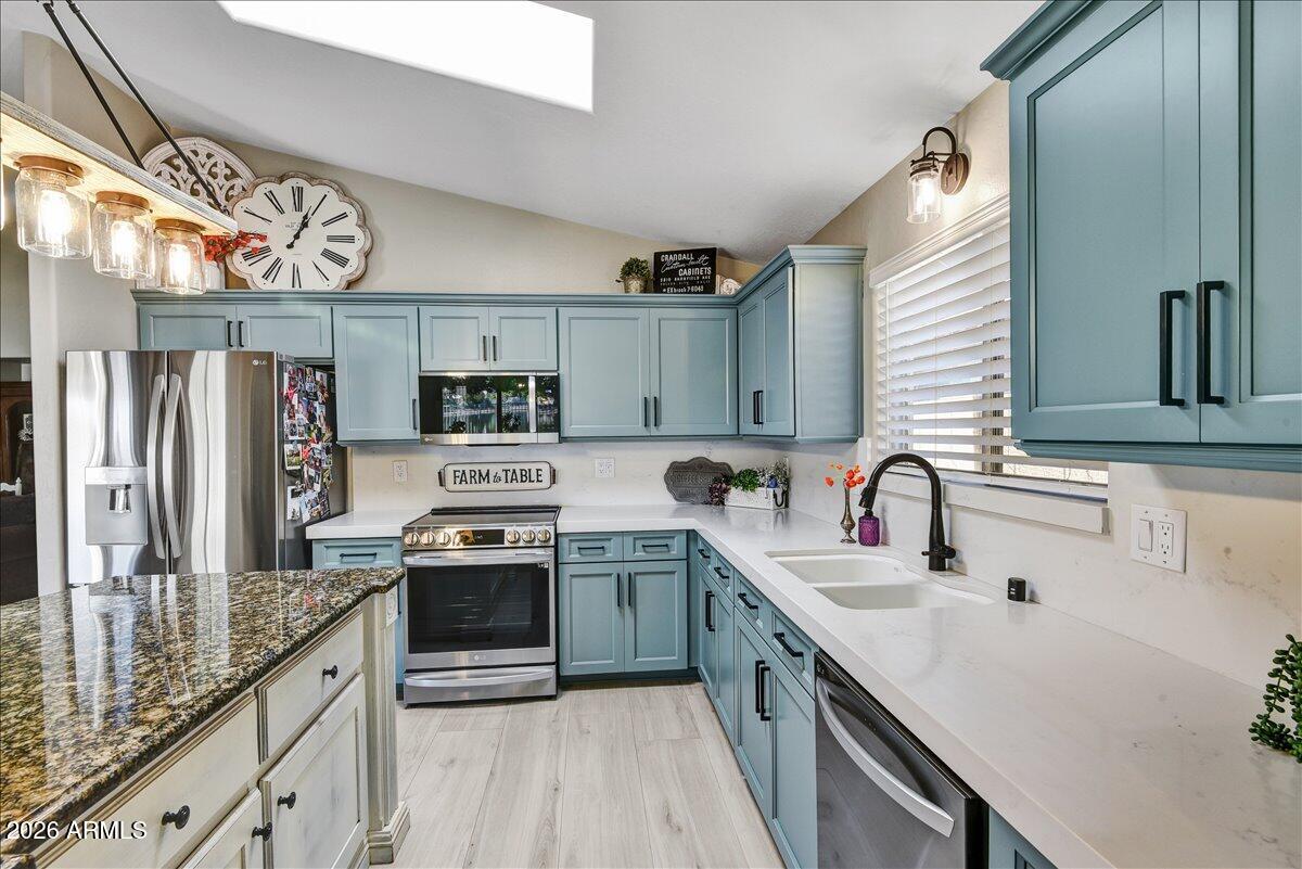 10830 West Almeria Road Avondale, AZ 85392 - Photo 14 of 27 a kitchen with stainless steel appliances granite countertop a sink stove and refrigerator