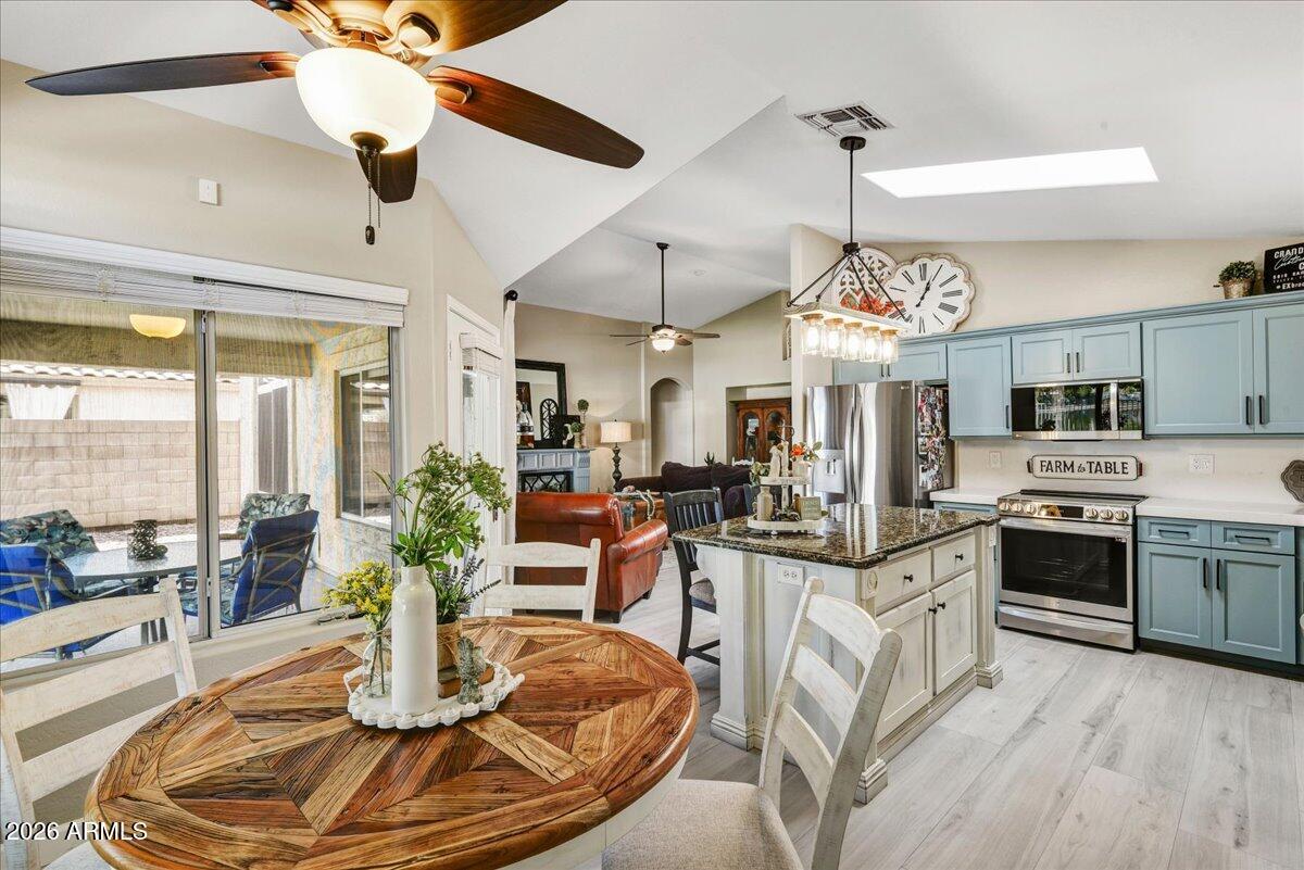 10830 West Almeria Road Avondale, AZ 85392 - Photo 16 of 27 a view of a dining room with furniture a kitchen and chandelier