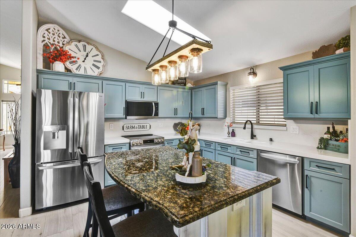 10830 West Almeria Road Avondale, AZ 85392 - Photo 6 of 27 a kitchen with stainless steel appliances granite countertop a sink refrigerator and microwave