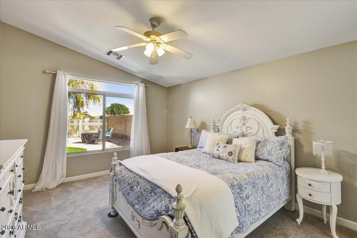 10830 West Almeria Road Avondale, AZ 85392 - Photo 8 of 27 a bedroom with a large bed and a chandelier