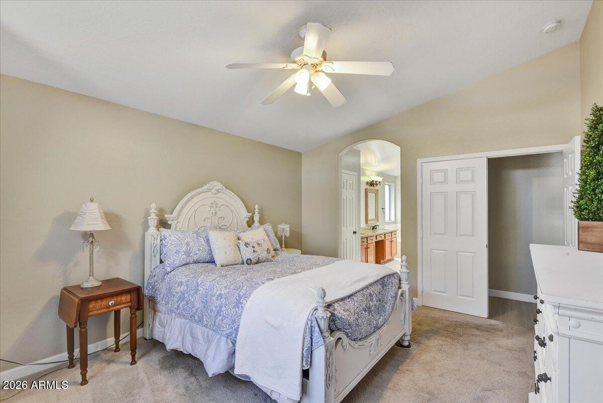 10830 West Almeria Road Avondale, AZ 85392 - Photo 9 of 27 a bedroom with a large bed and a chandelier