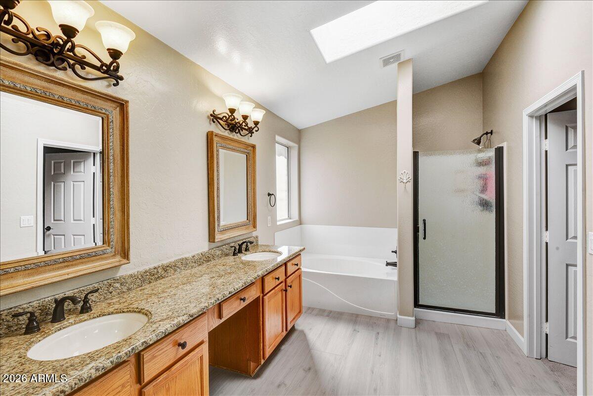 10830 West Almeria Road Avondale, AZ 85392 - Photo 10 of 27 a spacious bathroom with a granite countertop tub sink and mirror
