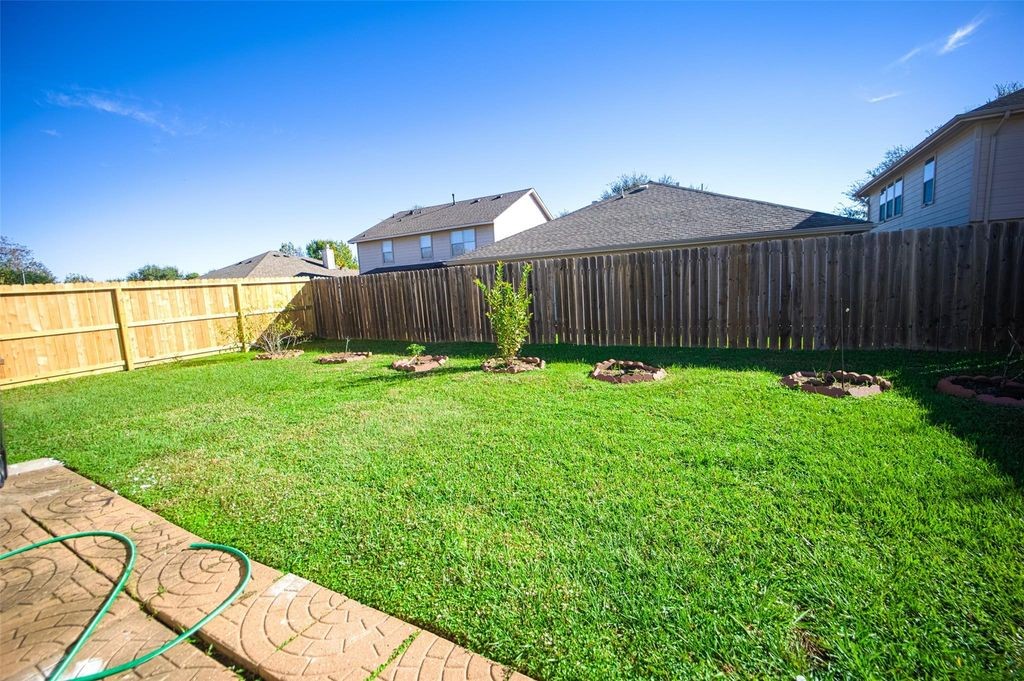 9611 Prairie Dog Run Sugar Land, TX 77498 - Photo 12 of 12 a backyard of a house with plants and wooden fence