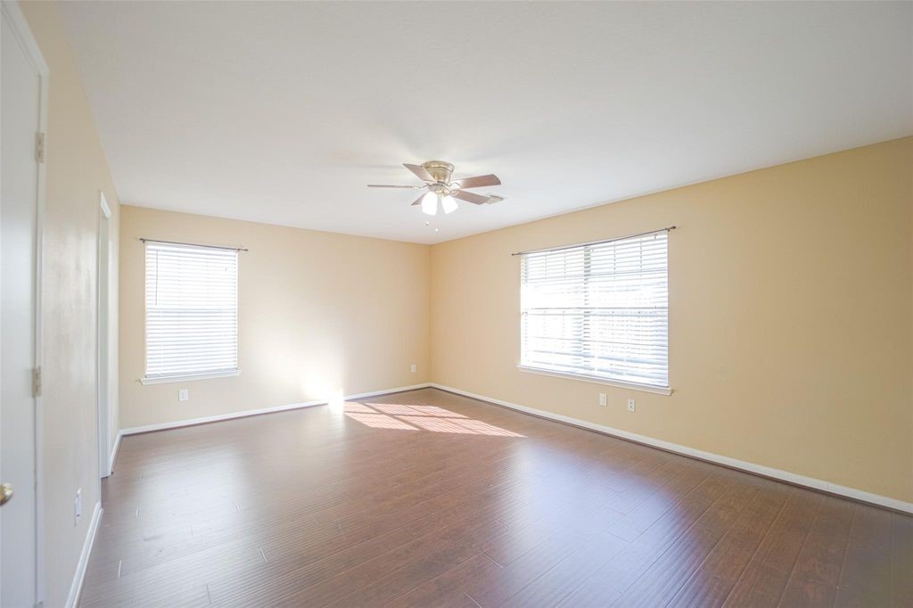 9611 Prairie Dog Run Sugar Land, TX 77498 - Photo 5 of 12 an empty room with wooden floor and windows