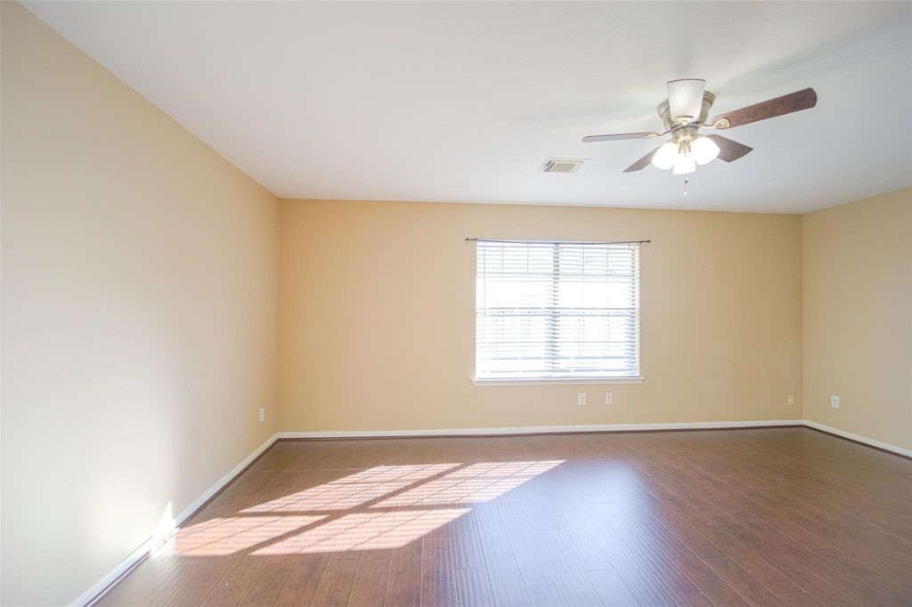 9611 Prairie Dog Run Sugar Land, TX 77498 - Photo 6 of 12 a view of an empty room with window and wooden floor