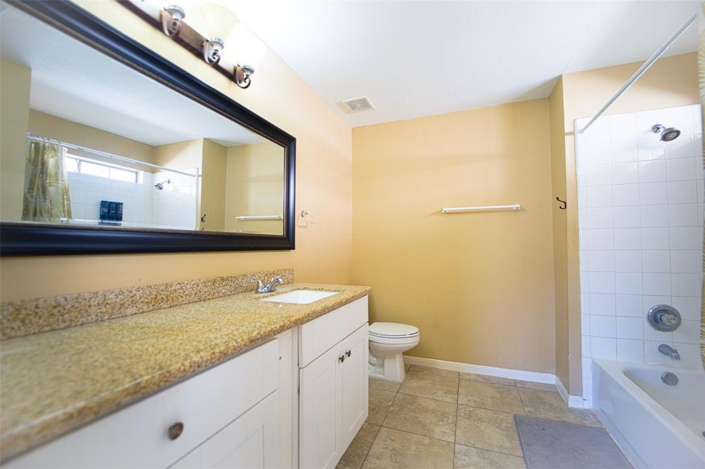 9611 Prairie Dog Run Sugar Land, TX 77498 - Photo 7 of 12 a bathroom with a sink a mirror and a bathtub