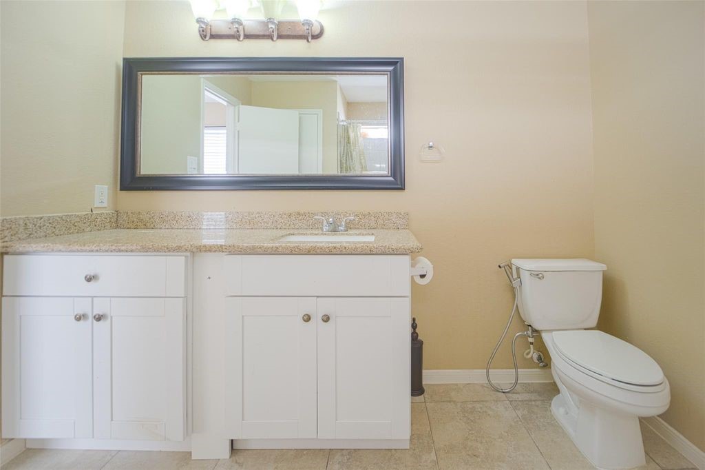 9611 Prairie Dog Run Sugar Land, TX 77498 - Photo 8 of 12 a bathroom with a toilet sink and mirror