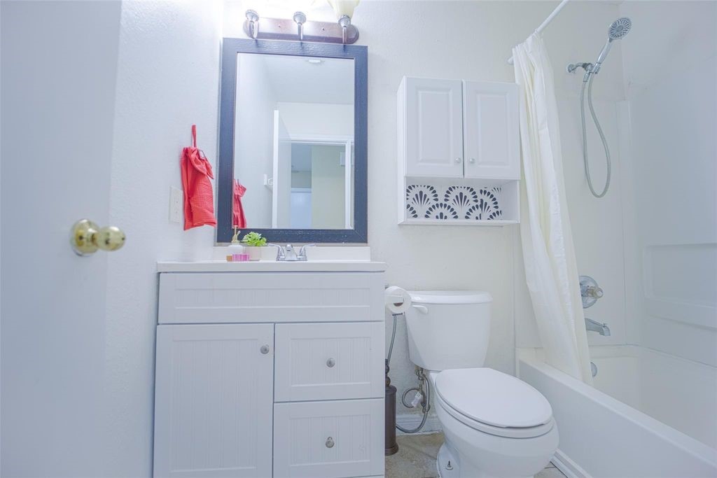 9611 Prairie Dog Run Sugar Land, TX 77498 - Photo 10 of 12 a bathroom with a toilet sink vanity and mirror