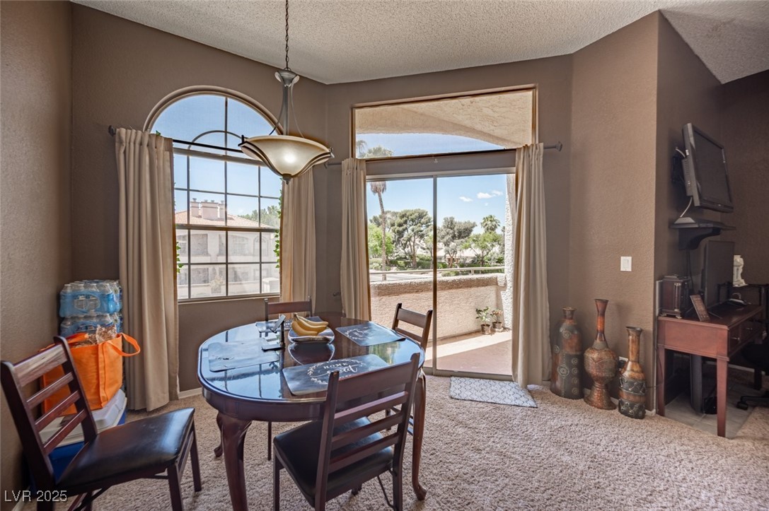 3150 North Soft Breezes Drive, Unit 2220 Las Vegas, NV 89128 - Photo 17 of 32 Carpeted dining area featuring a textured wall and a textured ceiling