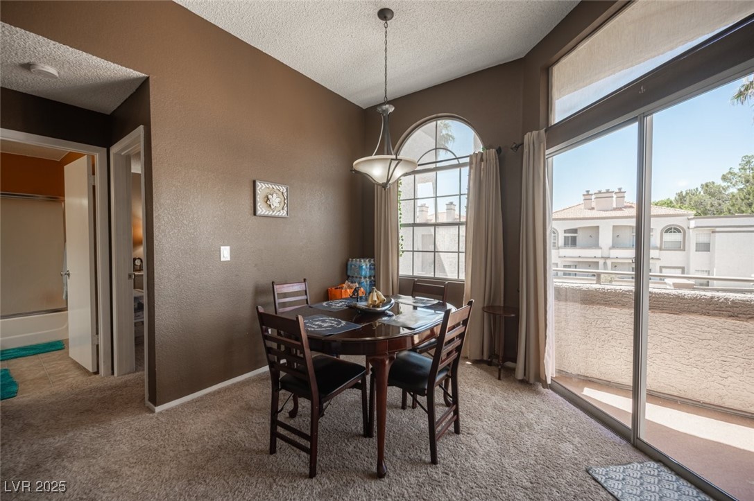 3150 North Soft Breezes Drive, Unit 2220 Las Vegas, NV 89128 - Photo 20 of 32 Dining space with a textured wall, light colored carpet, and a textured ceiling