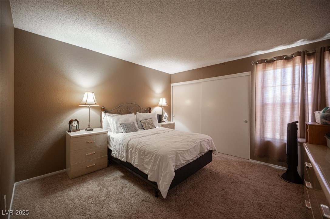 3150 North Soft Breezes Drive, Unit 2220 Las Vegas, NV 89128 - Photo 25 of 32 Bedroom with a textured ceiling, carpet flooring, a textured wall, and a closet