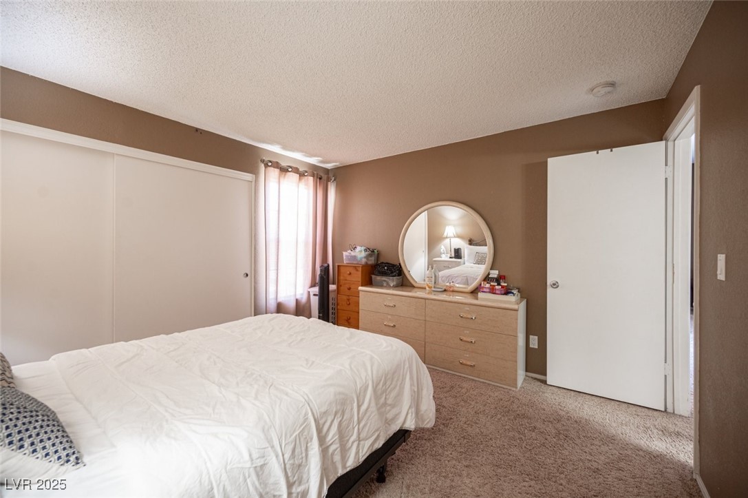 3150 North Soft Breezes Drive, Unit 2220 Las Vegas, NV 89128 - Photo 26 of 32 Carpeted bedroom with a textured ceiling and a closet
