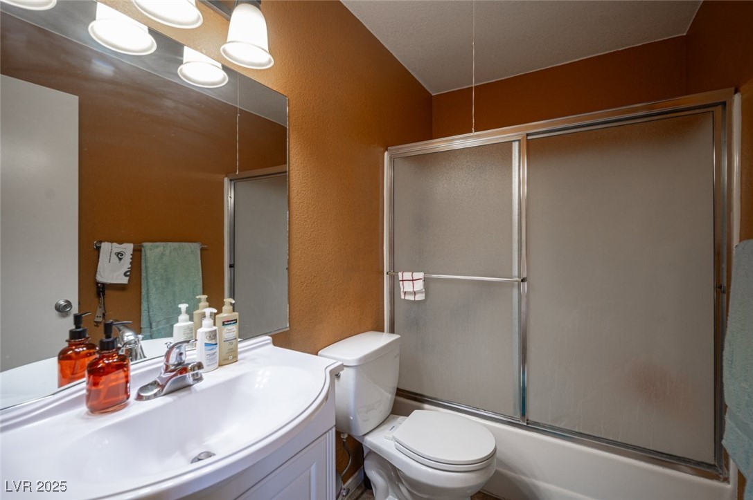 3150 North Soft Breezes Drive, Unit 2220 Las Vegas, NV 89128 - Photo 28 of 32 Full bathroom featuring a textured wall, shower / bath combination with glass door, and vanity