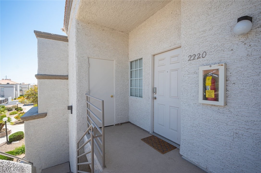 3150 North Soft Breezes Drive, Unit 2220 Las Vegas, NV 89128 - Photo 29 of 32 Doorway to property with stucco siding