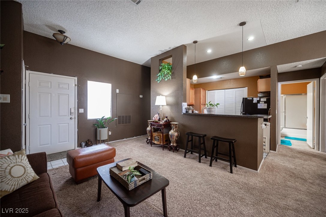 3150 North Soft Breezes Drive, Unit 2220 Las Vegas, NV 89128 - Photo 10 of 32 Living area with a textured ceiling and light carpet