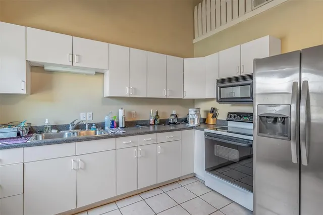 a kitchen with cabinets stainless steel appliances and a sink