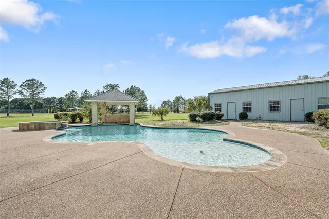 a view of a house with swimming pool and a yard