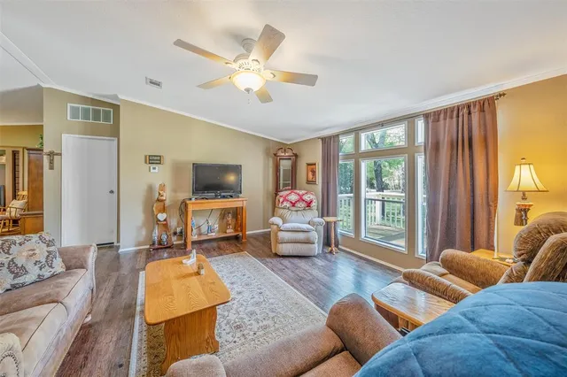 a kitchen with stainless steel appliances granite countertop a refrigerator a stove a sink dishwasher and white cabinets with wooden floor