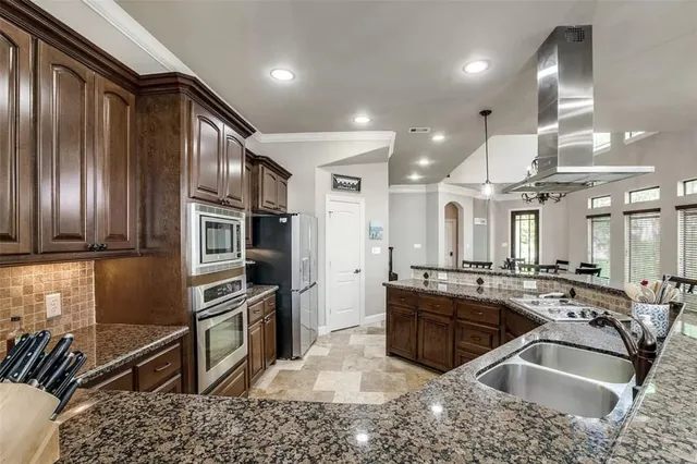 a kitchen with stainless steel appliances granite countertop a sink stove and refrigerator