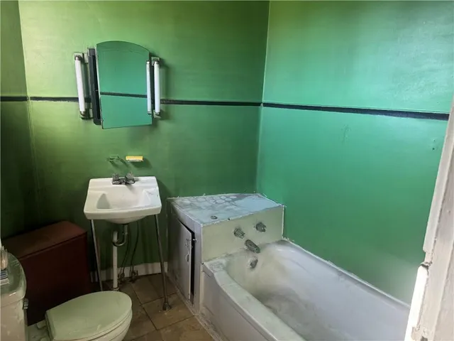 a bathroom with a sink toilet and mirror