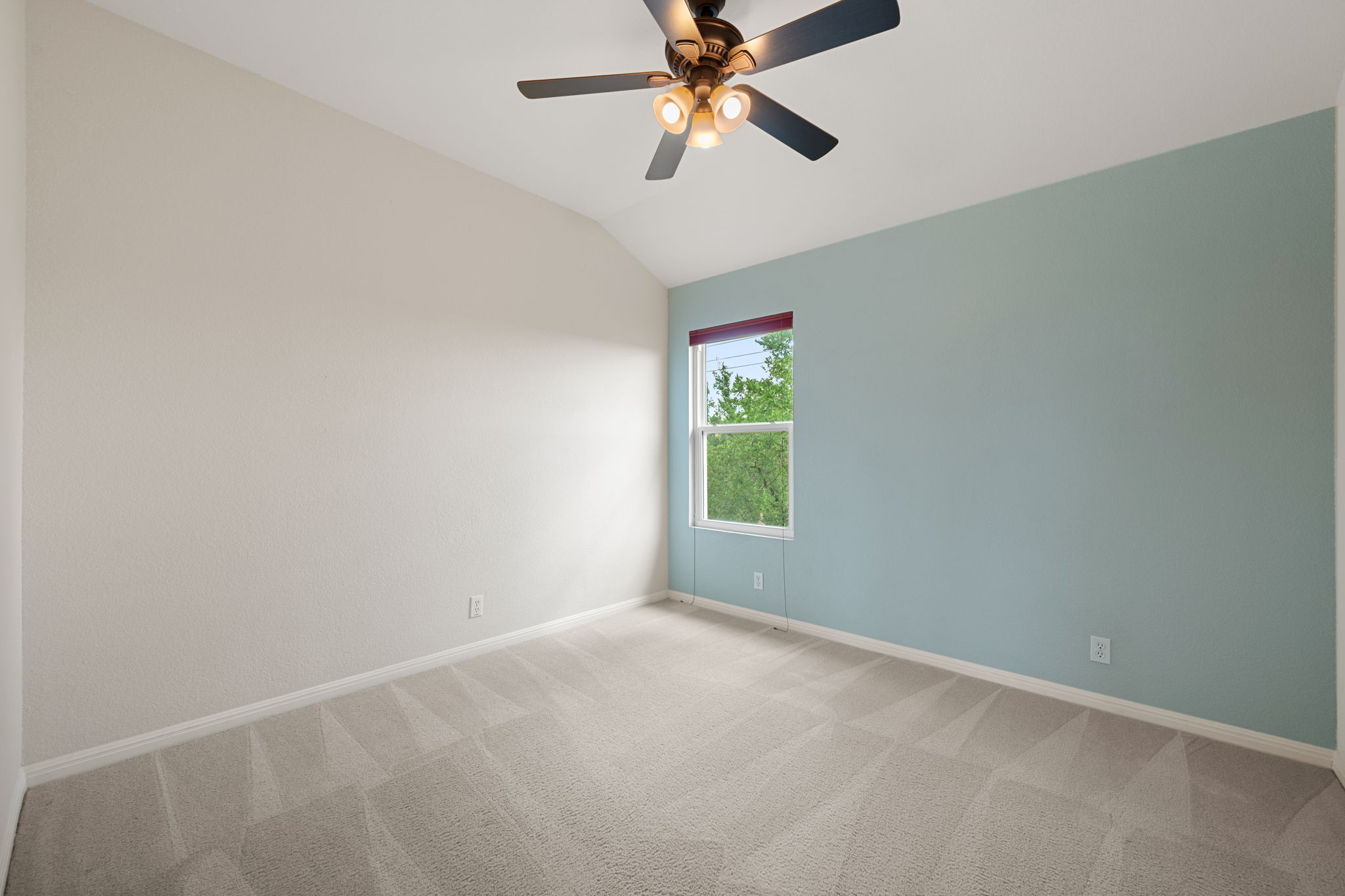 8902 Magna Carta Loop, Unit 122 Austin, TX 78754 - Photo 27 of 39 A window-filled bedroom with a vaulted ceiling and a ceiling fan for comfort.
