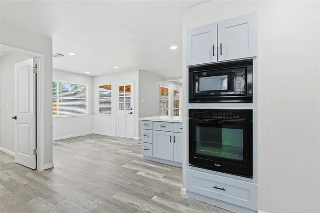 a kitchen with cabinets stainless steel appliances and a window