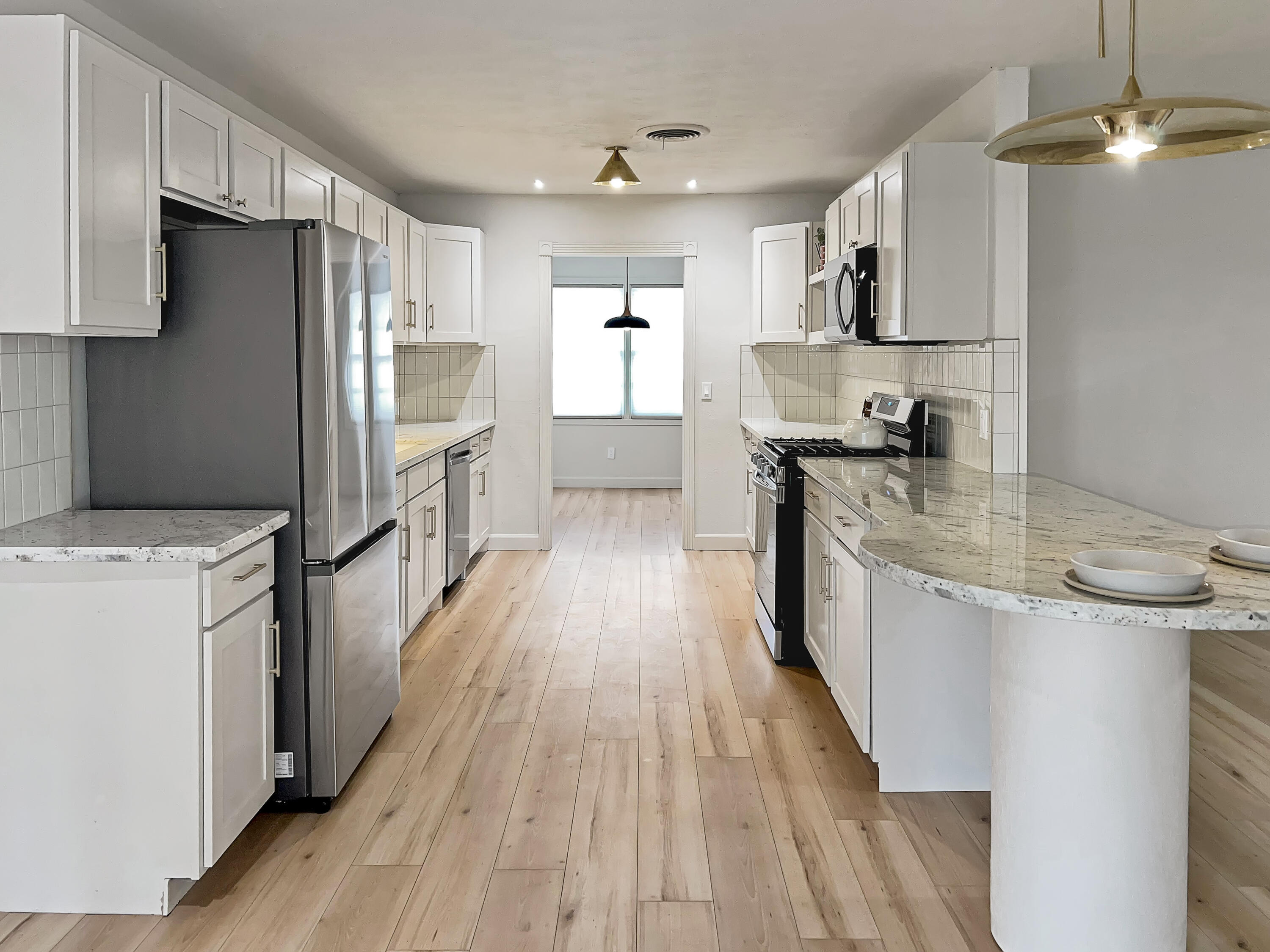 3827 52nd Street Lubbock, TX 79413 - Photo 6 of 24 a kitchen with kitchen island granite countertop wooden floors stainless steel appliances a sink and a stove